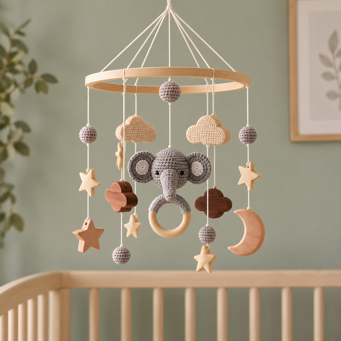 Mobile éléphant au-dessus d'un lit en bois, chambre vert sauge
